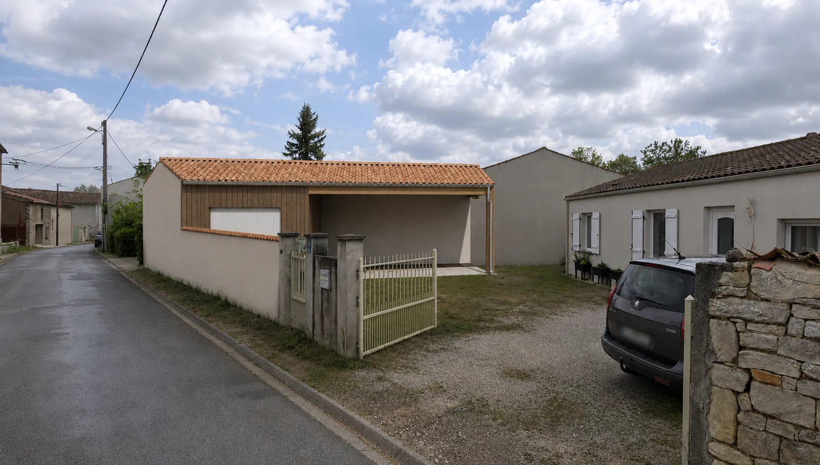 Insertion paysagère du garage avec bardage bois et auvent